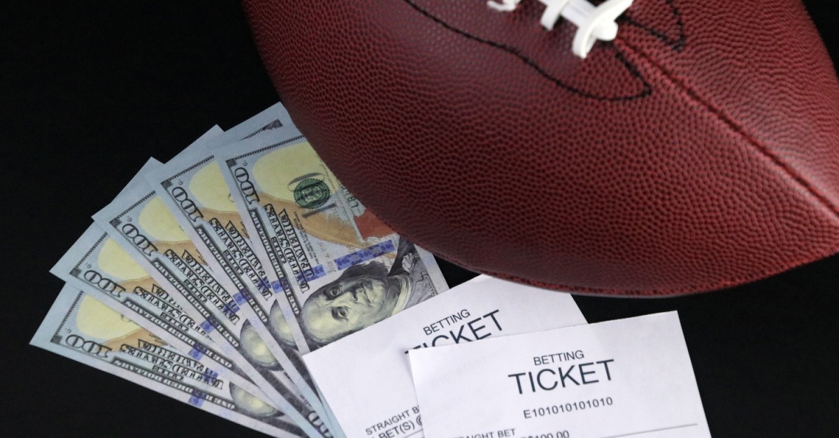 A football with money and sports betting tickets, the rise of sports gambling
