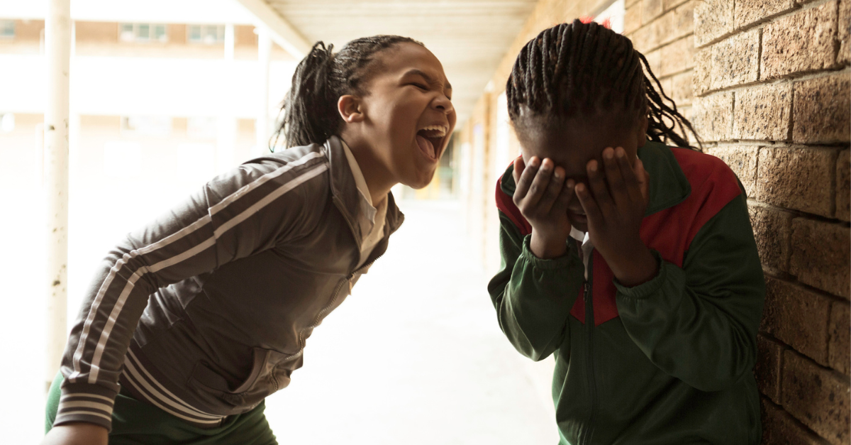 One girl picking on another on the playground